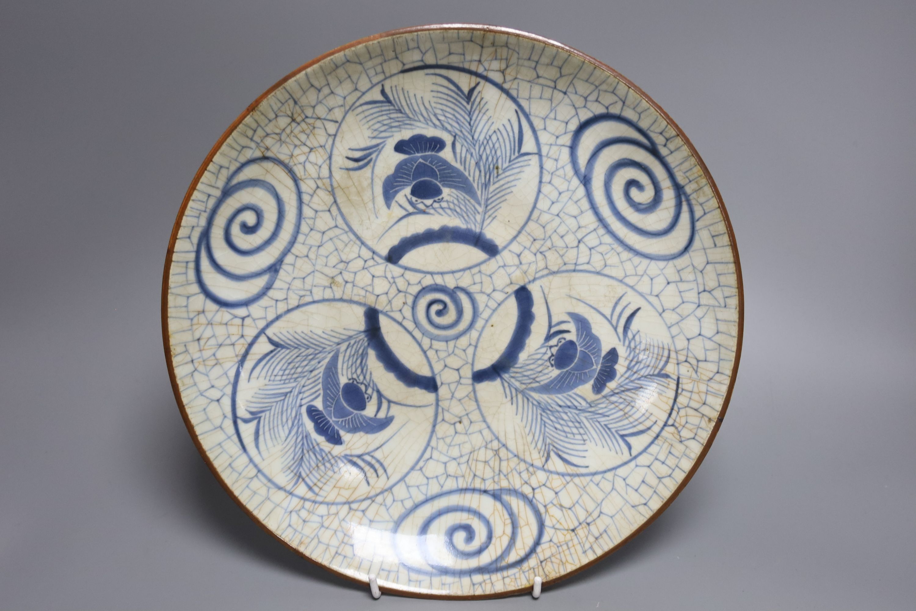 A Japanese crackle glazed dish, another similar and a Chinese celadon glazed dish, largest diameter 29.5cm